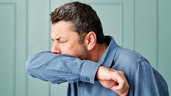 man sneezing into his arm.jpg